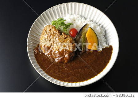 A bird's-eye view of a coarse hamburger curry with stewed vegetables and parsley on a black background A bird's-eye view of a coarse hamburger curry with stewed vegetables and parsley on a black background 88390132