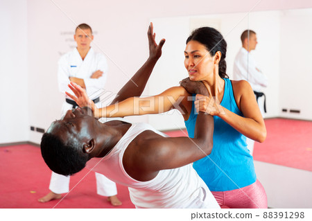 People training martial arts in gym with trainer People training martial arts in gym with trainer 88391298