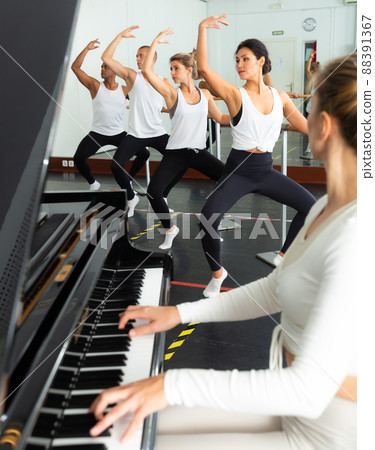 Woman and man doing barre workout in dance hall Woman and man doing barre workout in dance hall 88391367