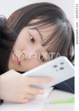 High school girls watching smartphone High school girls watching smartphone 88392515