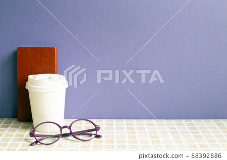 Notebook and coffee cup, glasses on desk. purple wall background. workspace 88392886