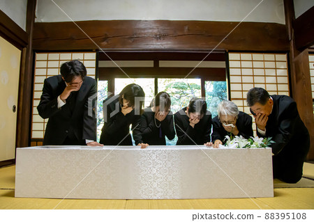 Relatives crying at the coffin ceremony of the funeral 88395108