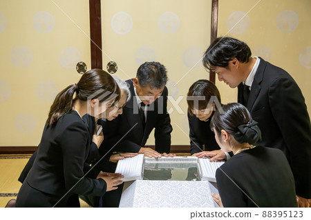 The bereaved family performing the encoffining ceremony at the funeral 88395123