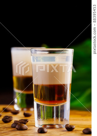 Shots of flaming B-52 cocktail placed on a bar counter. B-52 shot composed of three liqueurs 88395453