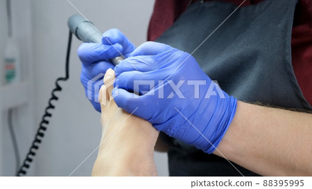 Pedicure SPA procedure in the beauty salon. Peeling feet. Electric apparatus for pedicure. Close up 88395995