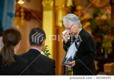 一位在葬禮上用肖像問候的主祭老婦人(主祭的問候,哭泣) 一位在葬禮上用肖像問候的主祭老婦人(主祭的問候,哭泣) 88396095