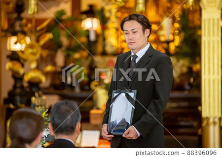 一位日本男性哀悼者在葬禮上用死者的畫像問候（哀悼者的問候） 88396096