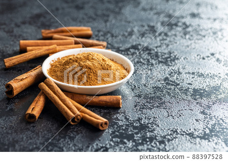 Dry cinnamon sticks and cinnamon powder on black table. Cinnamon spice. Dry cinnamon sticks and cinnamon powder on black table. Cinnamon spice. 88397528
