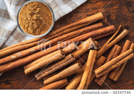 Dry cinnamon sticks and cinnamon powder on wooden table. Cinnamon spice. 88397546