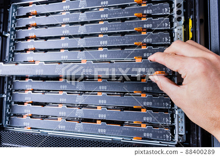 network administrator installing data storage hardware from sever rack 88400289