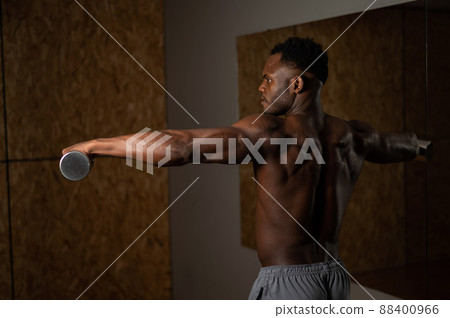 Attractive african american man doing arm exercises with dumbbells. Attractive african american man doing arm exercises with dumbbells. 88400966