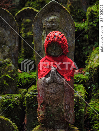 Jizo wearing a red haori and a hood 88403091