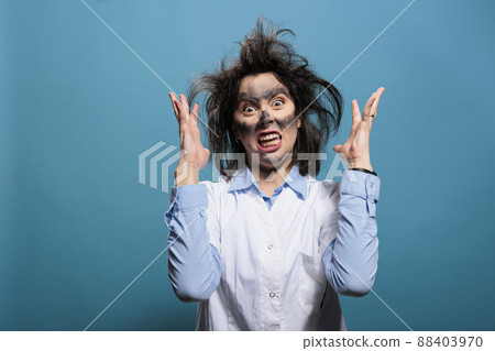 Mad biochemist with amusing look after laboratory explosion being angry while gesturing with rage. Goofy looking crazy scientist with dirty face and messy hair after failed chemical experiment. 88403970