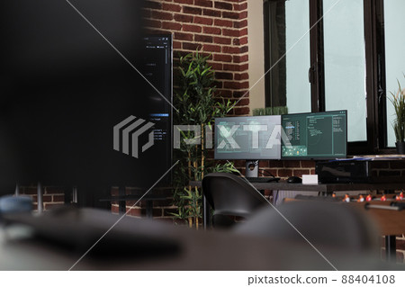 Interior of server room with modern brick wall interior and high quality hardware and software technology. Empty data center office with multiple computer screens showing programming line codes. 88404108