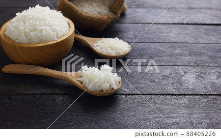 Close up spoon of fluffy Thai jasmine rice and another in bowl against black Close up spoon of fluffy Thai jasmine rice and another in bowl against black 88405226