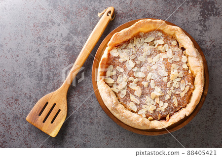 Bakewell Pudding is a sweet tart, a crisp pastry case filled with sweet almond sponge over raspberry jam closeup. Horizontal top view 88405421