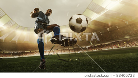 Professional soccer player in action at the stadium with flashlights hitting the ball for the winning goal, wide angle. Concept of sport, competition, movement, overcoming. Professional soccer player in action at the stadium with flashlights hitting the ball for the winning goal, wide angle. Concept of sport, competition, movement, overcoming. 88406728
