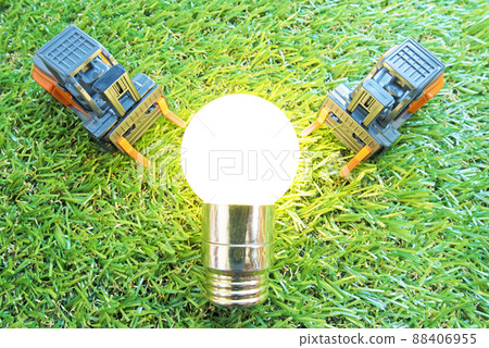 Two forklifts placed on the lawn and a light bulb lit in the middle 88406955