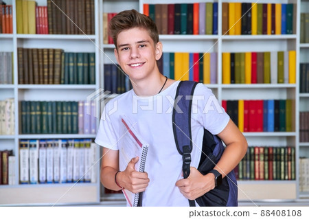 Portrait of male teenage student looking into the camera in library 88408108