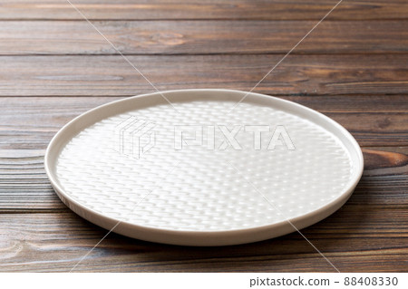 Perspective view of empty light plate on wooden background. Empty space for your design 88408330