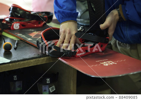 工作人員在滑雪場租賃處手動調整滑雪板綁定尺寸 88409085