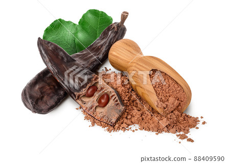 Carob pod and powder in wooden scoop isolated on white background with clipping path and full depth of field. 88409590