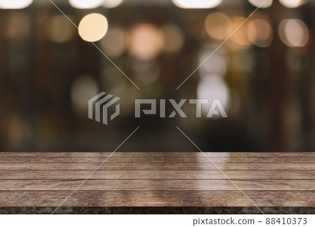 Empty wooden table top with lights bokeh on blur restaurant background. Empty wooden table top with lights bokeh on blur restaurant background. 88410373