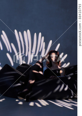 woman in black bodysuit in the backlight of a photo studio. 88410793