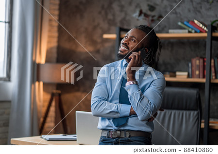 Cheerful employee smiling during the phone talk Cheerful employee smiling during the phone talk 88410880
