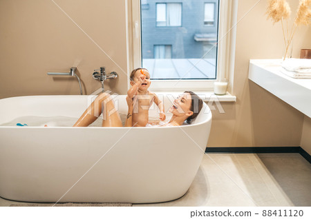 Joyful mother playing with her baby in the bathtub 88411120