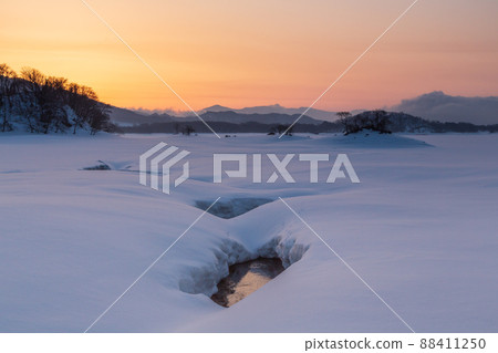 Sunrise from Lake Hibara in spring to snowy fields 88411250