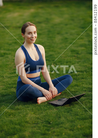 Beautiful girl in a park. Sports girl in a sportswear. Woman with laptop. Beautiful girl in a park. Sports girl in a sportswear. Woman with laptop. 88412199