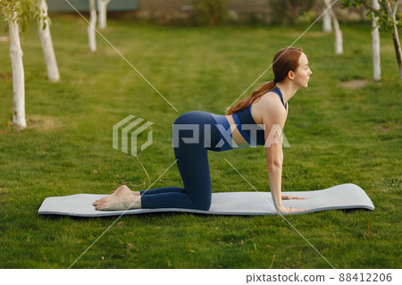 Beautiful girl training. Girl in a summer park. Lady make a yoga 88412206