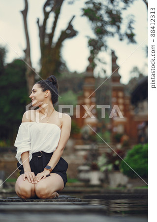 girl exploring a beautiful park in Bali. Brunette girl dressed in stylish clothing posing in a beautiful location girl exploring a beautiful park in Bali. Brunette girl dressed in stylish clothing posing in a beautiful location 88412313