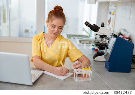 Woman vet sitting at desk in animal clinic Woman vet sitting at desk in animal clinic 88412487