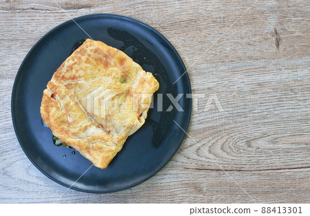 fried mashed pork with tomato and onion stuffed in Thai egg omelets on dish 88413301