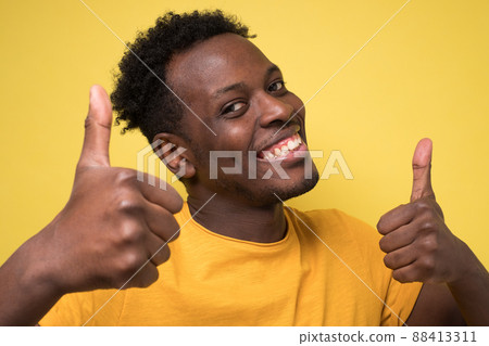 happy african american handsome man laughing and showing thumb up gesture happy african american handsome man laughing and showing thumb up gesture 88413311