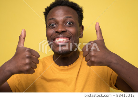 happy african american handsome man laughing and showing thumb up gesture happy african american handsome man laughing and showing thumb up gesture 88413312