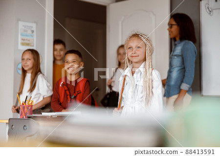 Happy children standing in class at school Happy children standing in class at school 88413591