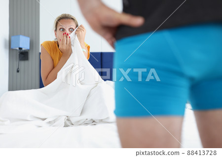 Amazed woman looks at man in bedroom Amazed woman looks at man in bedroom 88413728