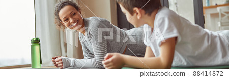 Cheerful mom enjoying workout with son indoors 88414872