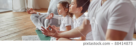 Parents doing meditation with kids at home Parents doing meditation with kids at home 88414873