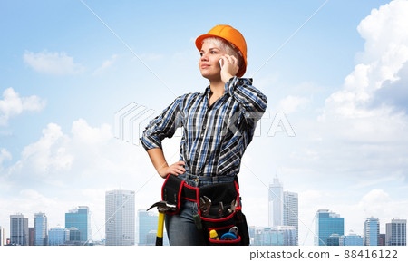 Attractive woman in workwear and hardhat 88416122