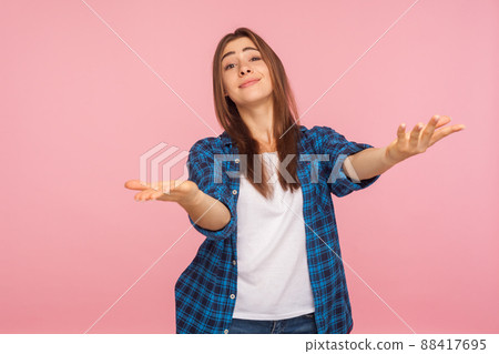 Portrait of generous kind-hearted girl in checkered shirt raising arms in gesture take everything for free, give me hug, looking hospitable and friendly. indoor studio shot isolated on pink background 88417695