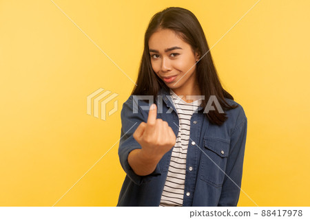Come closer, follow me. Portrait of lovely seductive beautiful woman in denim shirt enticing with finger beckoning gesture, inviting playfully hither. indoor studio shot isolated on yellow background 88417978