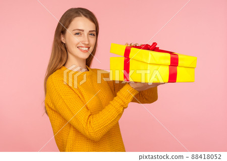 Portrait of attractive red hair girl in sweater opening gift box and smiling at camera, unboxing birthday surprise, satisfied with holiday present. indoor studio shot isolated on pink background 88418052