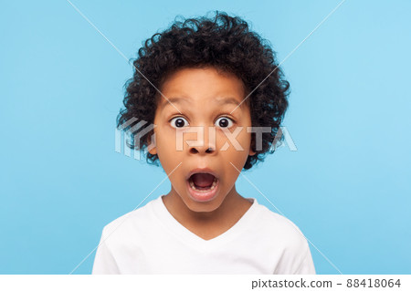 Wow, unbelievable. Portrait of funny amazed little boy looking at camera with shocked astonished expression, emotionally reacting to surprising news. indoor studio shot isolated on blue background Wow, unbelievable. Portrait of funny amazed little boy looking at camera with shocked astonished expression, emotionally reacting to surprising news. indoor studio shot isolated on blue background 88418064