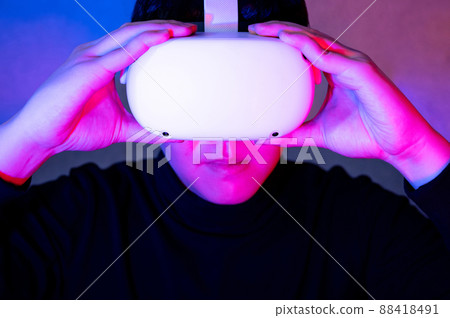 Asian gamer wearing VR headset playing games 88418491