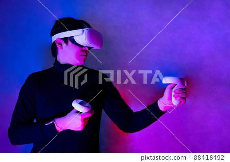 Asian gamer wearing VR headset playing games 88418492