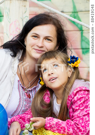 Flag Day of Independence of Ukraine. Stop WAR. Ukrainian girl in an embroidered vyshyvanka shirt with a yellow-blue flag of Ukraine. Symbols of the flag of Ukraine. Freedom. Russia terror. Kyiv.  88419148